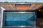 Overhead view of a pool with a sign that reads 'THOMSN'