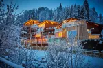 Snowy landscape with warmly lit wooden buildings