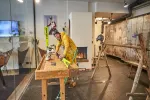 Person arbeitet mit Werkzeugen in einem Werkraum