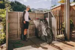 Man stands in a bike maintenance area next to a bicycle