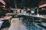 Modern restaurant interior with bar, seating, and decorative lighting