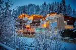 Cozy wooden houses illuminated in a snowy landscape.