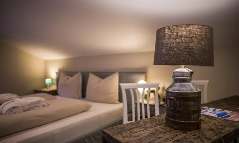 gemütliches Schlafzimmer mit einem Bett, einem Holztisch und einer Lampe