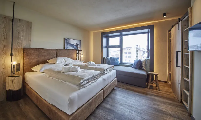 Moderne Hotelzimmer mit Doppelbett und Ausblick aus einem großen Fenster