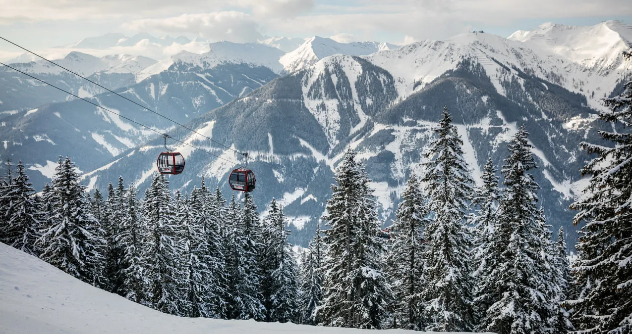 Blick auf verschneite Berge und eine Seilbahn im Skicircus Saalbach-Hinterglemm-Leogang-Fieberbrunn