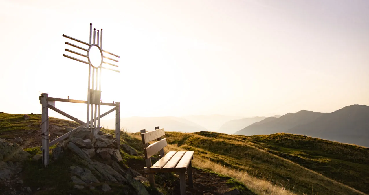 Aussichtspunkt mit einer Bank und einem Holzkreuz in Saalbach-Hinterglemm