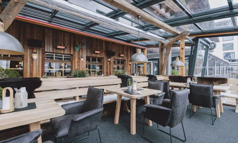 Moderne Terrasse mit Holzmöbeln und großen Fenstern