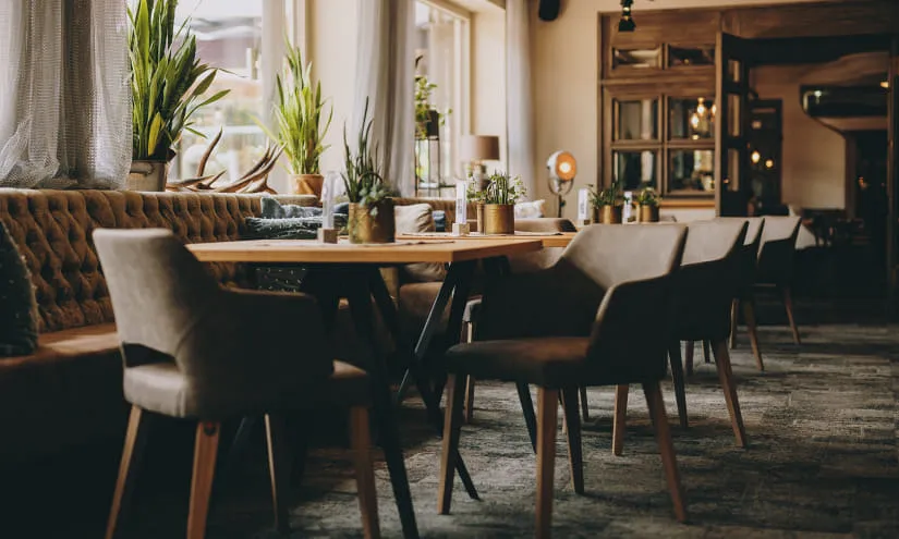 gemütliches Restaurantinterieur mit Pflanzen und Holztischen