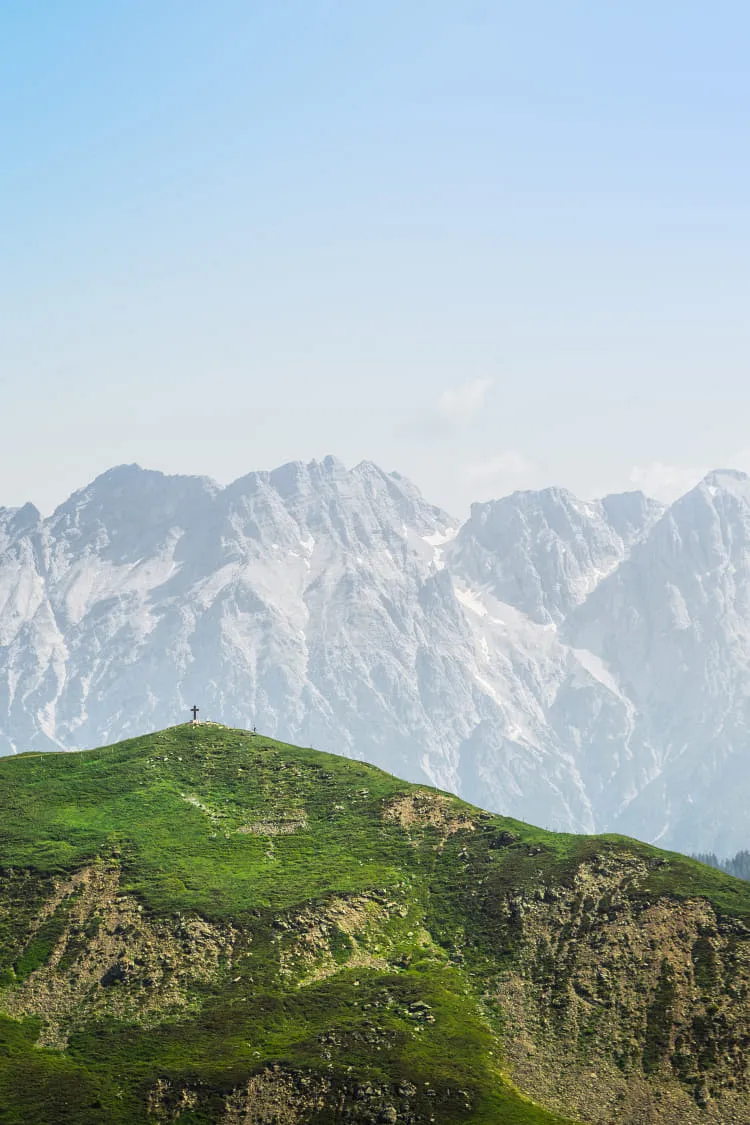 Blick vom Stemmerkogel zum Mittelgipfel mit grünen Hügeln im Vordergrund.