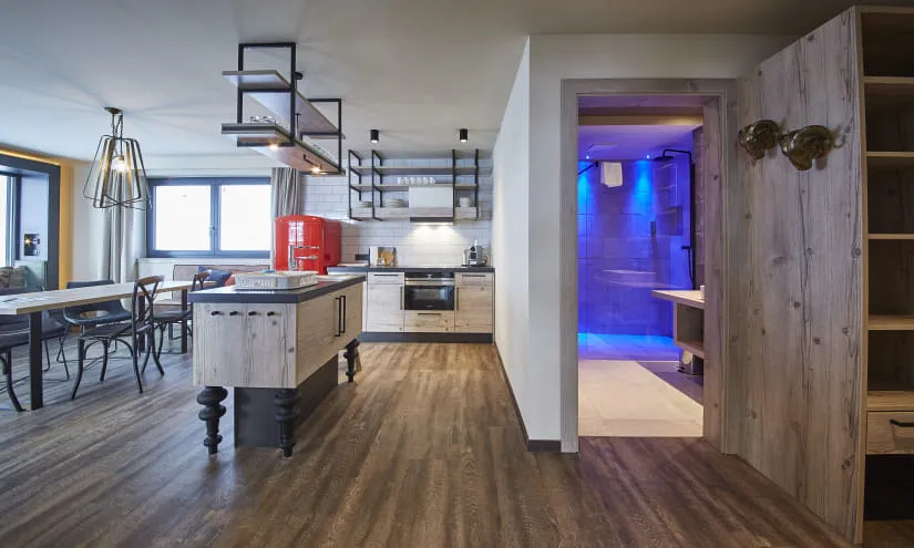 Moderne Küche mit Holzmöbeln und blauer Beleuchtung im Hintergrund