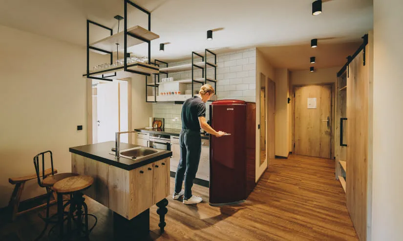 Moderne Küche mit Holzmöbeln und Kühlschrank in einer Wohnung.