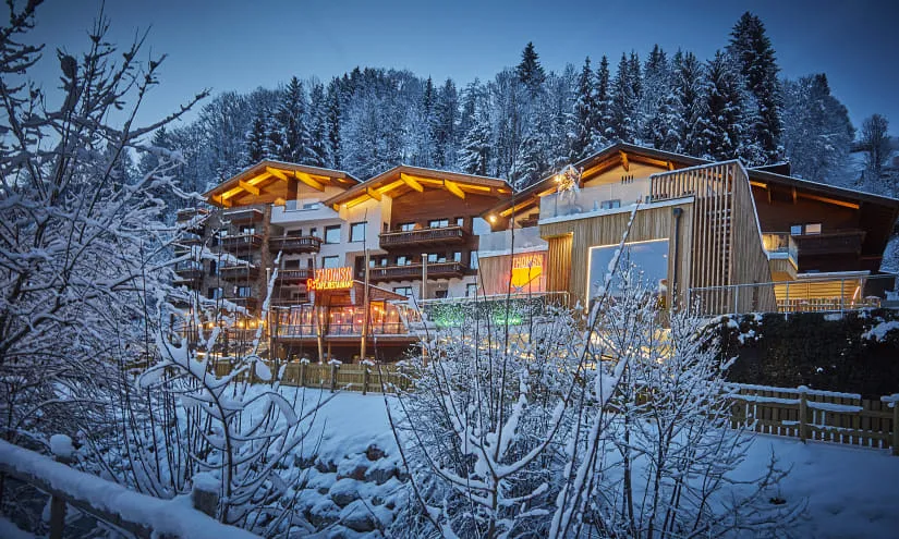 Winterszene mit einem gemütlichen Lodge in einer verschneiten Landschaft