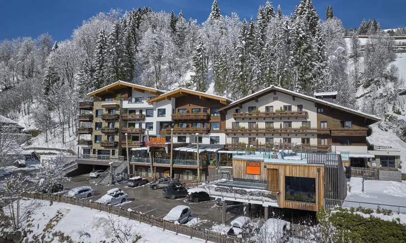Winterlandschaft mit zentralem Heimatgebäude und schneebedeckten Bäumen