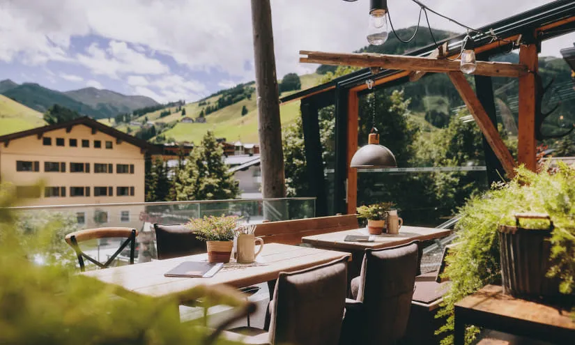 Sommerrestaurant mit Tischen und Blick auf die Berge