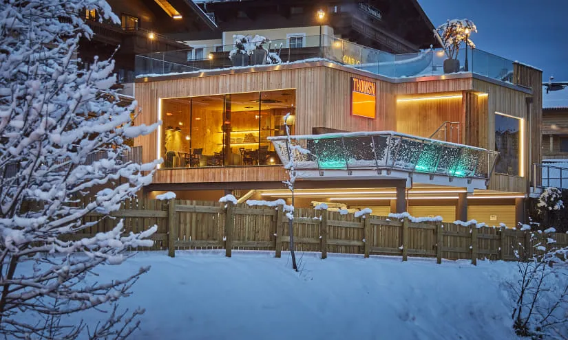 Modernes Gebäude in verschneiter Landschaft mit beleuchtetem Außenbereich