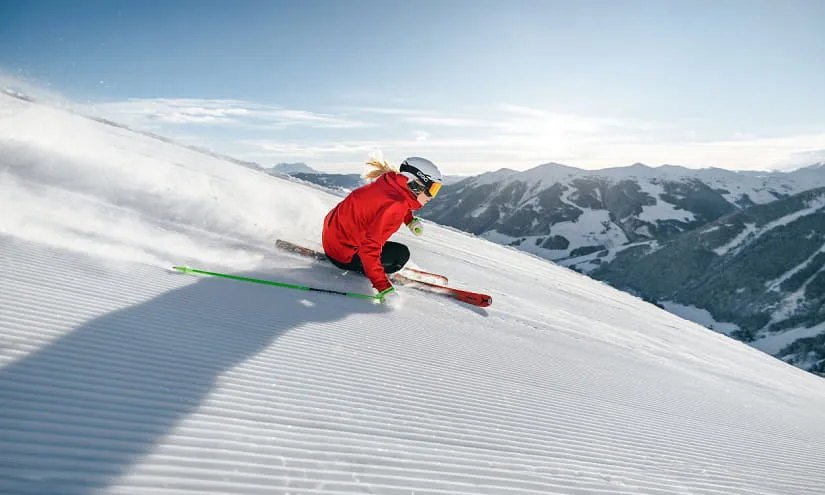 Skifahrer auf einer stark präparierten Piste in Saalbach-Hinterglemm