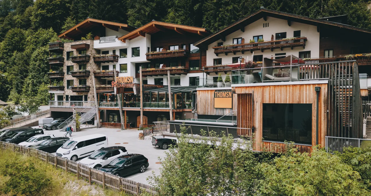 Modern accommodation with balconies, parking lot, and surrounding nature