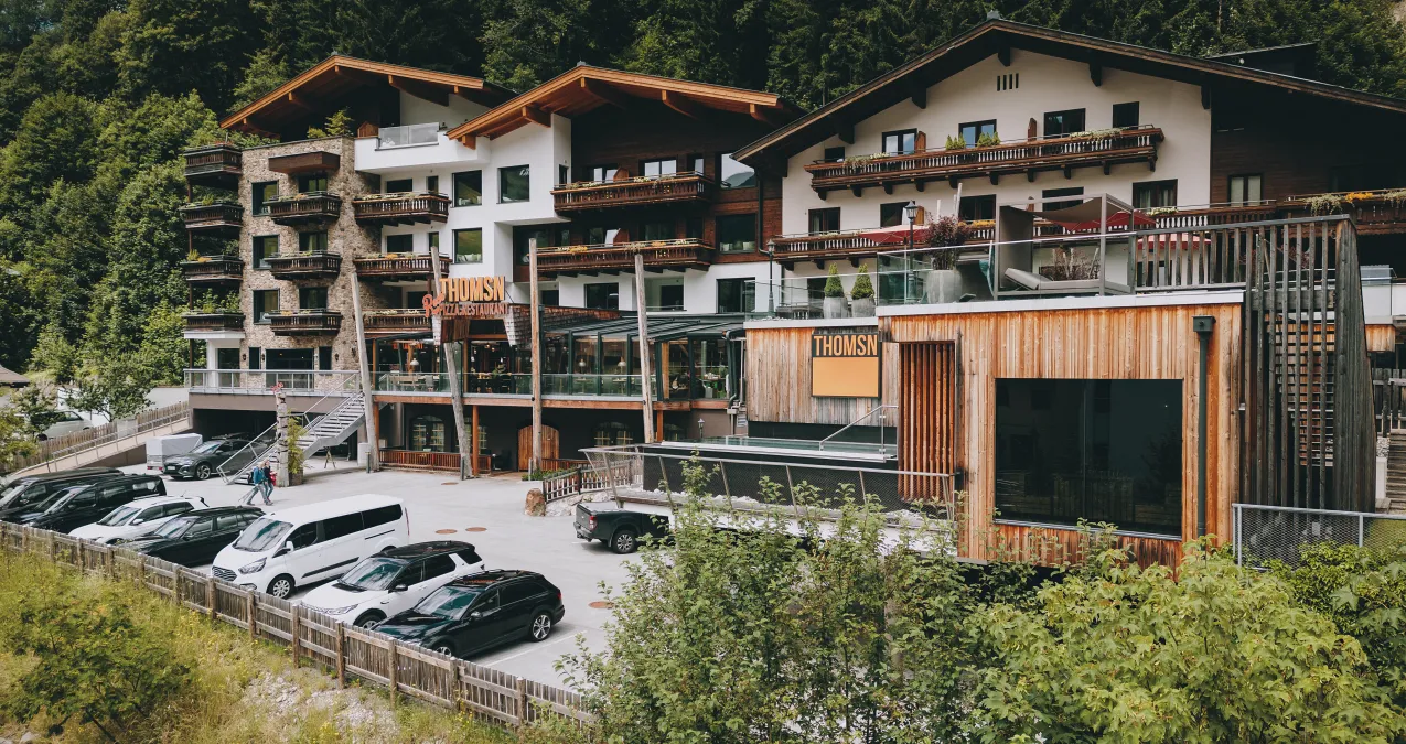 Außenansicht des Thomsn, Parkplatz und umgebende Natur