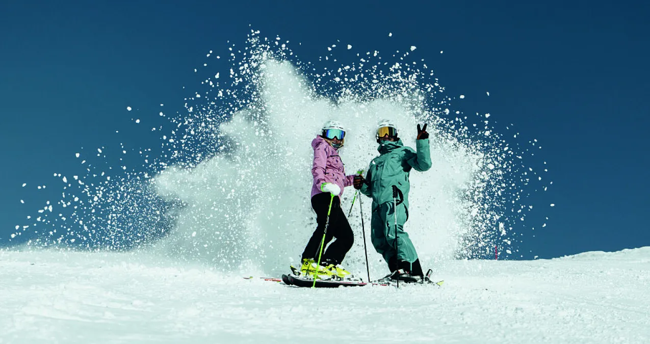 Two skiers on snowy slope in Skicircus Saalbach-Hinterglemm-Leogang-Fieberbrunn