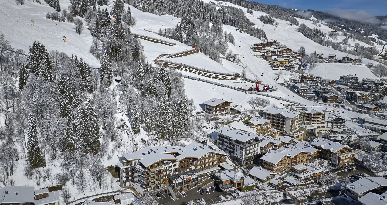 Blick auf verschneite Berge und ein Dorf mit Ferienwohnungen