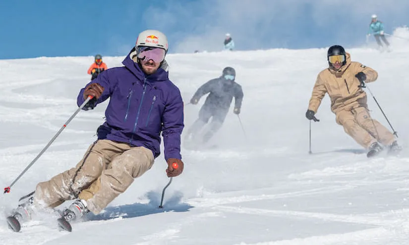 Skifahrer auf einer verschneiten Piste bei sonnigem Wetter