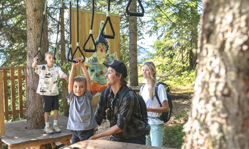 Familie genießt den Montelinos Erlebnisweg mit Kletterelementen.