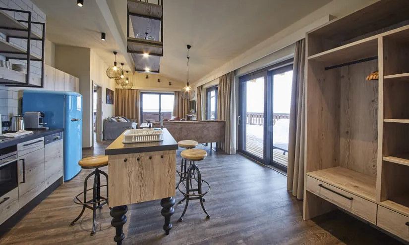 Moderne Küche mit Holzregalen und Fenster zur Terrasse.