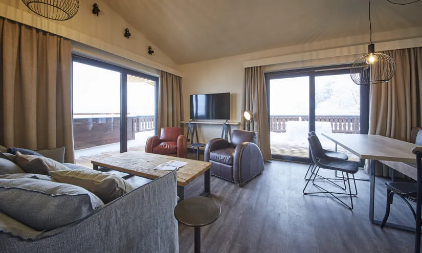 moderne Wohnzimmer mit Holztisch, Sesseln und Fernseher