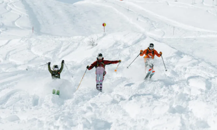Drei Skifahrer genießen Freeride im tiefen Schnee auf einer Winterskipiste
