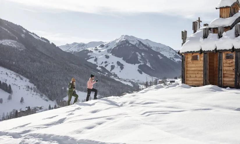 Zwei Personen beim Schneeschuhwandern in den Bergen von Saalbach.