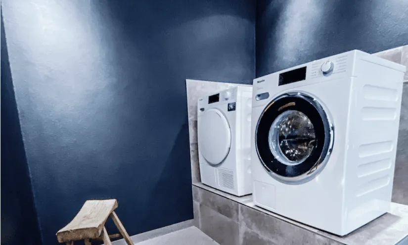 Modern washer and dryer in a dark room.