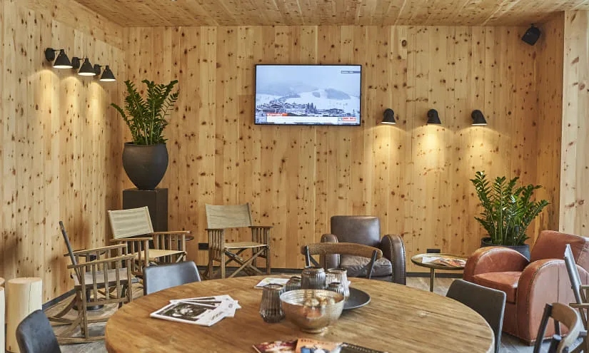 Holzwand mit Pflanzen, Fernseher und Sitzgelegenheiten