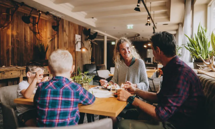 Dining scene with a woman and two boys at a wooden table