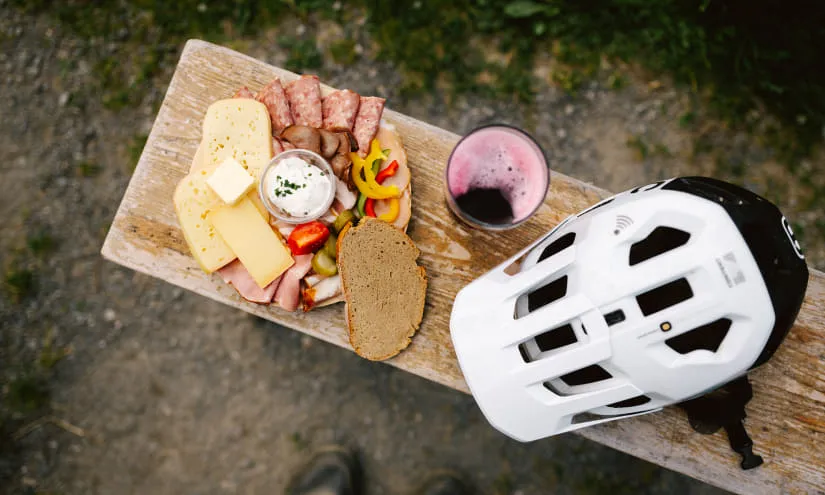 Plate of food and bike helmet on a wooden surface